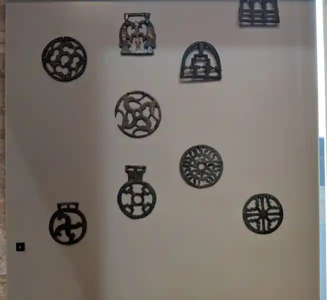 Display of decorative bronze and glass Merovingian discs and mounts